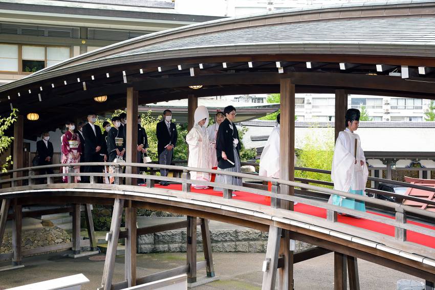 いよいよ挙式。神主様の先導でお太鼓橋を渡り神殿へ。